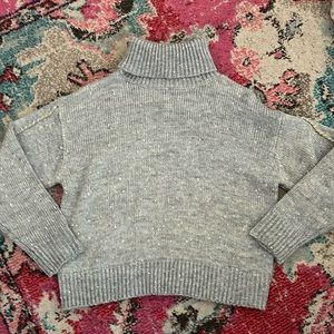 Grey turtle neck with gold stitching on the arms